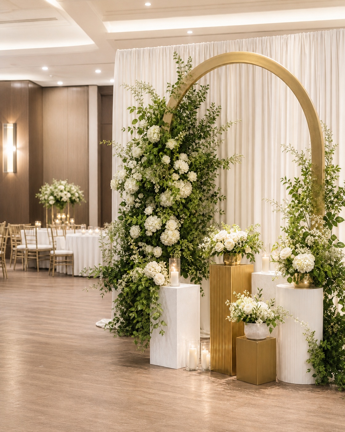 Ivory floral arch, greenery and coordinated decor plinths